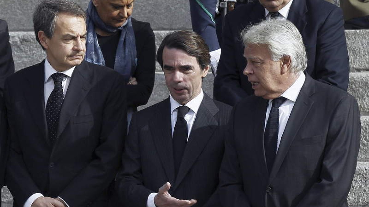 Zapatero, Aznar y González juntos ayer en la puerta del Congreso a la espera de la llegada del féretro de Suárez.