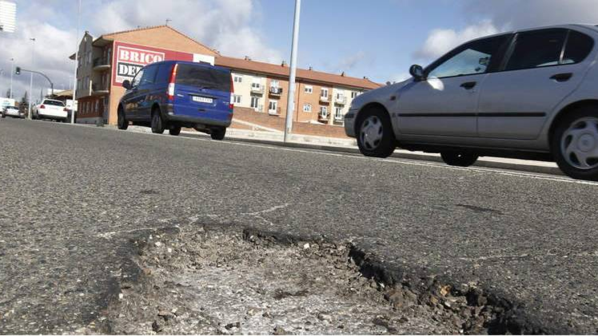 Estado de la carretera de Asturias, donde hay varios baches, en una fotografía reciente.