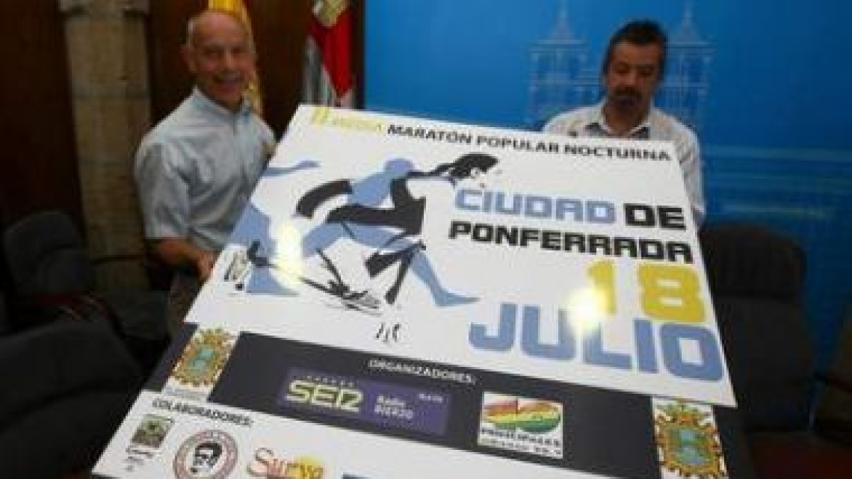 Emilio Villanueva y Francisco Martínez posan con el cartel de la prueba.