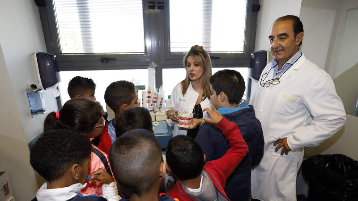 José Sevilla, a la derecha, con una de las responsables del programa de salud bucodental y los niños que acudieron ayer.