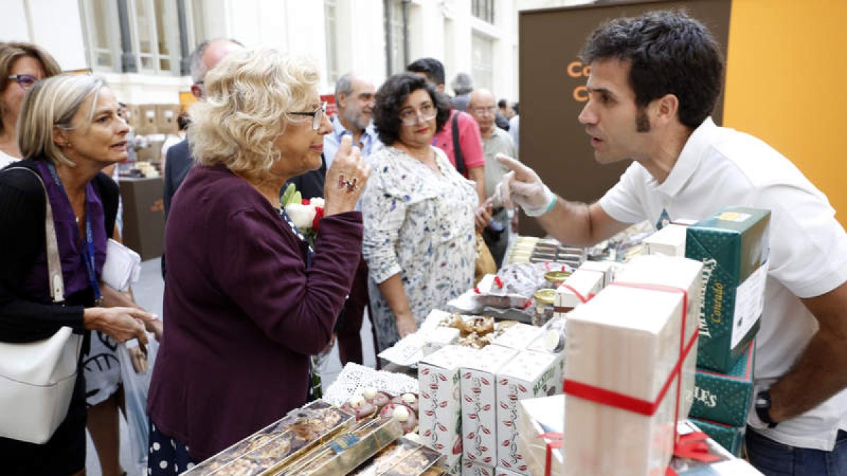 La alcaldesa de Madrid, Manuela Carmena, charla atentamente con el confitero bañezano Sergio González. RAQUEL P. VIECO