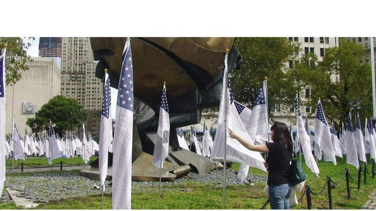 Una mujer observa una de las 2.976 banderas con los nombres de las víctimas de los ataques terroristas del 2001 en Nueva York y Washington.