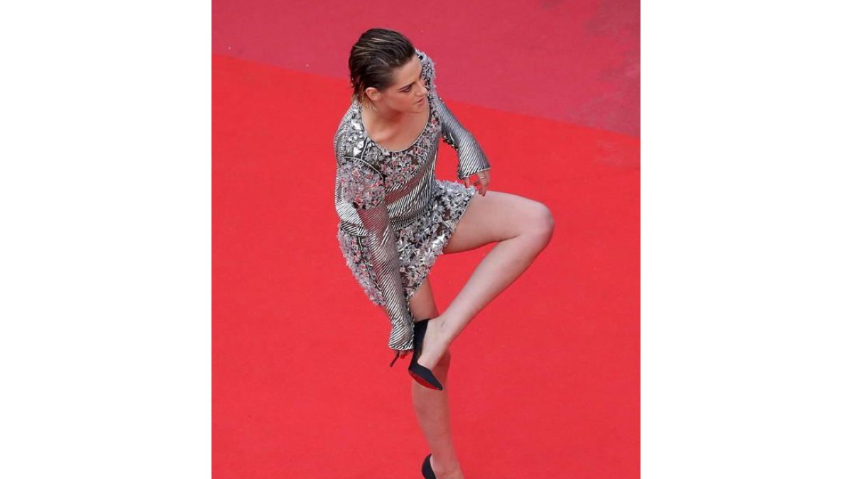 La actriz estadounidense Kristen Stewart se quita los zapatos para subir la escalera a su llegada a la presentación de 