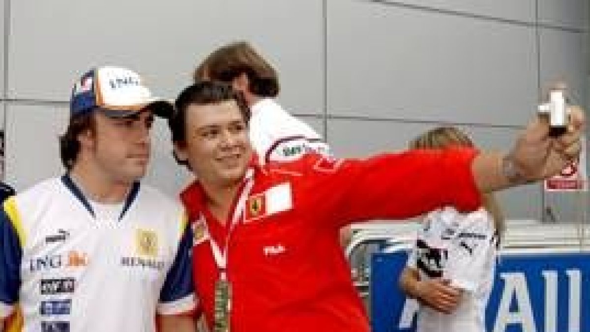 Un seguidor de Ferrari se hace una fotografía con Fernando Alonso