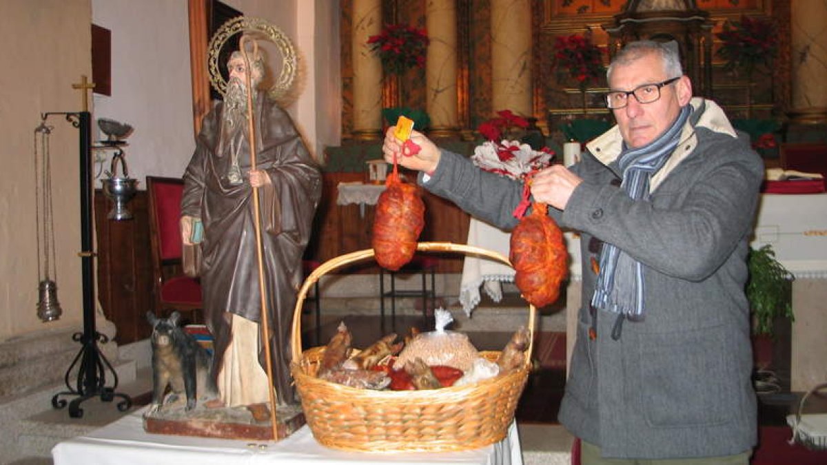 El sacristán de Toral de Merayo con la cesta de productos subastada.