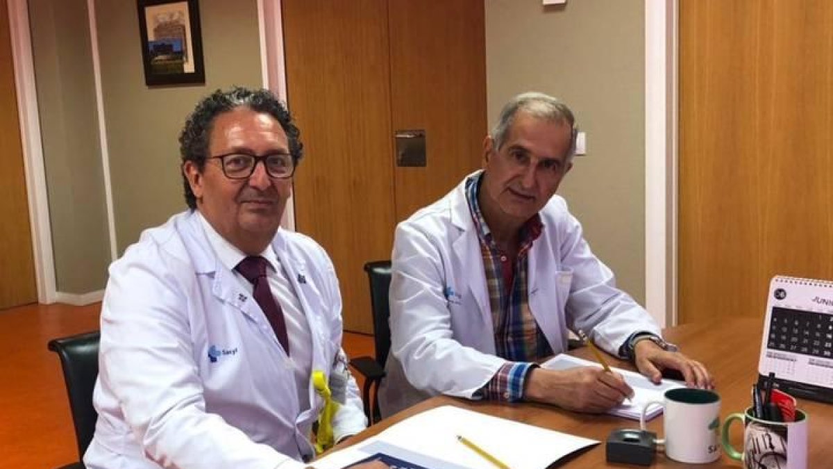 El gerente del Hospital Universitario de León, Juan Luis Burón, y el doctor Miguel Ángel Rodríguez García, firman la diligencia de toma de posesión como personal emérito