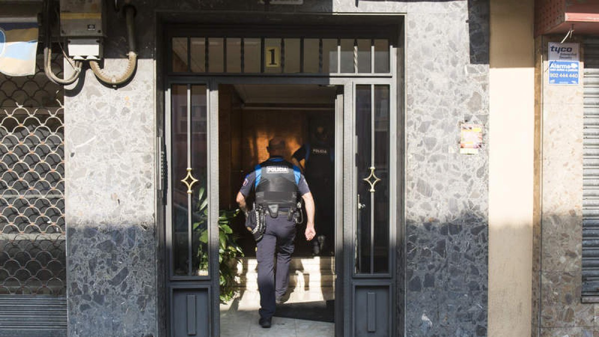 Agentes de la Policía Local llegan al portal del inmueble en el que se halló a la mujer. FERNANDO OTERO
