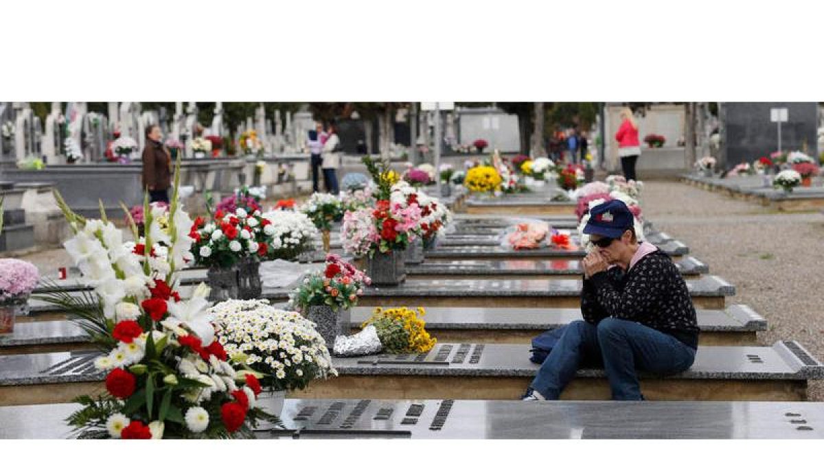 Una mujer acompaña a su familiar en el día de los difuntos en el cementerio de León