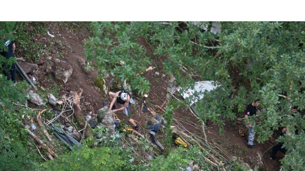 Equipos de rescate trabajan en el lugar donde cayó el autobús siniestrado.