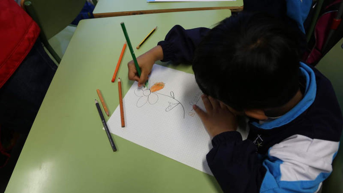 Un niño realiza un dibujo en las tareas de apoyo escolar y meriendas que los voluntarios de Cruz Roja llevan a cabo. SECUNDINO PÉREZ