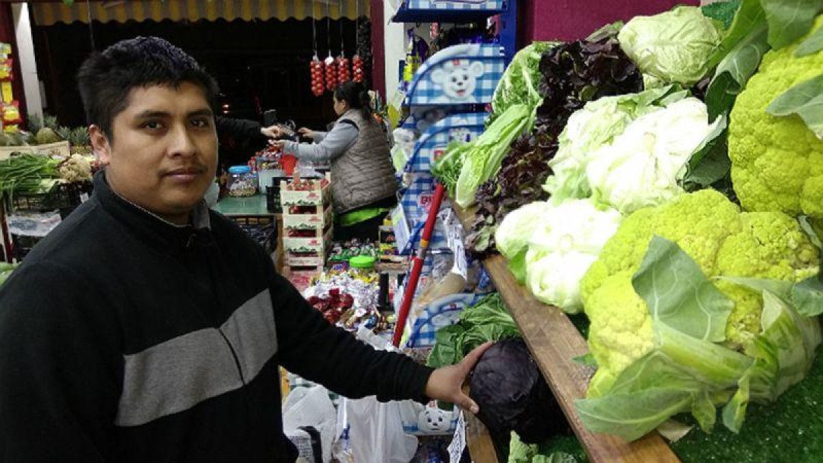 Éverson Fernández e Ibeth Kathia Suárez, al fondo, en su comercio de frutas y verduras de Barcelona.