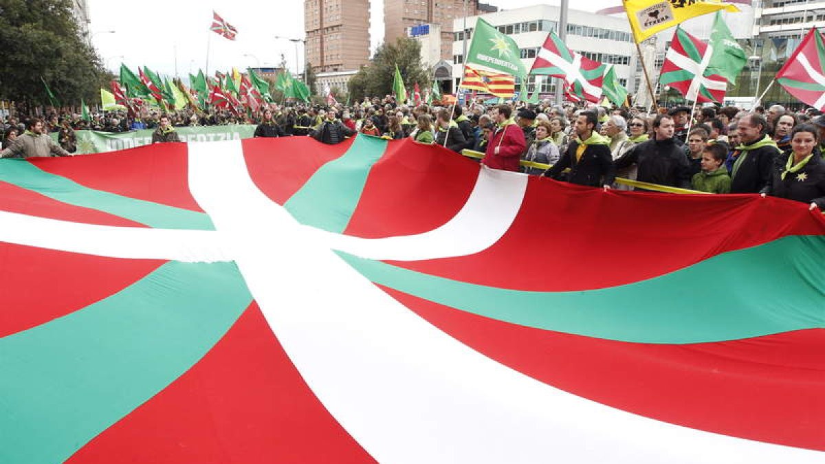 Una ikurriña preside la multidunaria manifestación exigiendo la independencia de Euskadi.