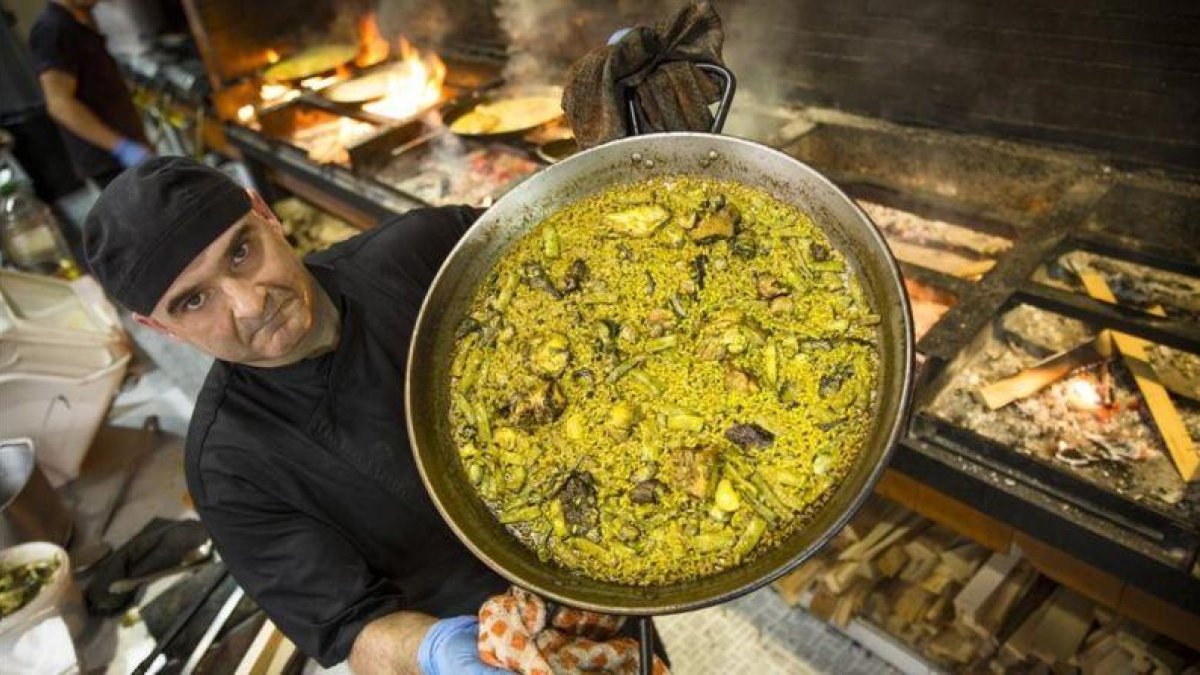 Luis, cocinero de Casa Carmela, en València, muestra una paella valenciana.