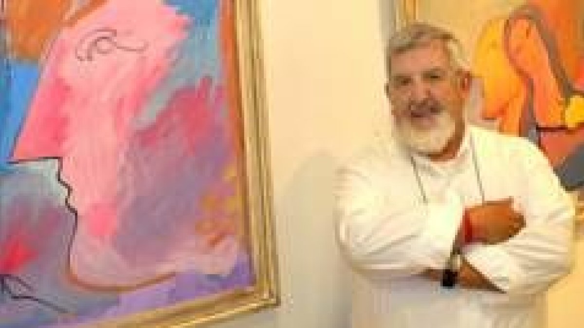 El artista Alberto Cavazos posa junto a dos de sus obras