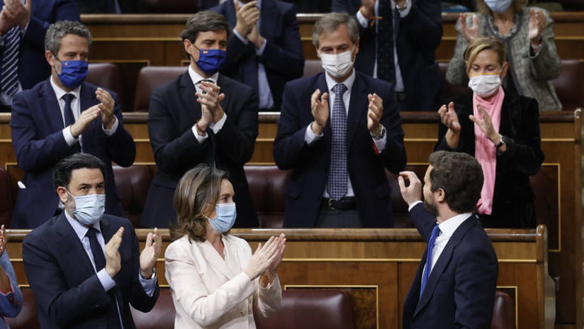 El líder del Partido Popular, Pablo Casado (d, delante), se despide de los diputados de su partido momentos antes de abandonar el hemiciclo tras su intervención en la sesión de control al Gobierno, este miércoles, en el Congreso de los Diputados. CHEMA MOYA