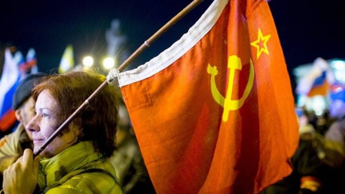 Una mujer sostiene una bandera soviética en la plaza de Lenin, en Simferopol, este domingo.