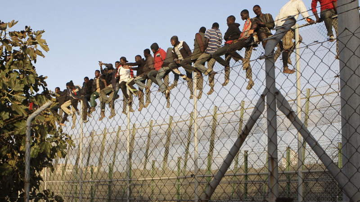 Inmigrantes encaramados a la valla de Melilla la semana pasada.