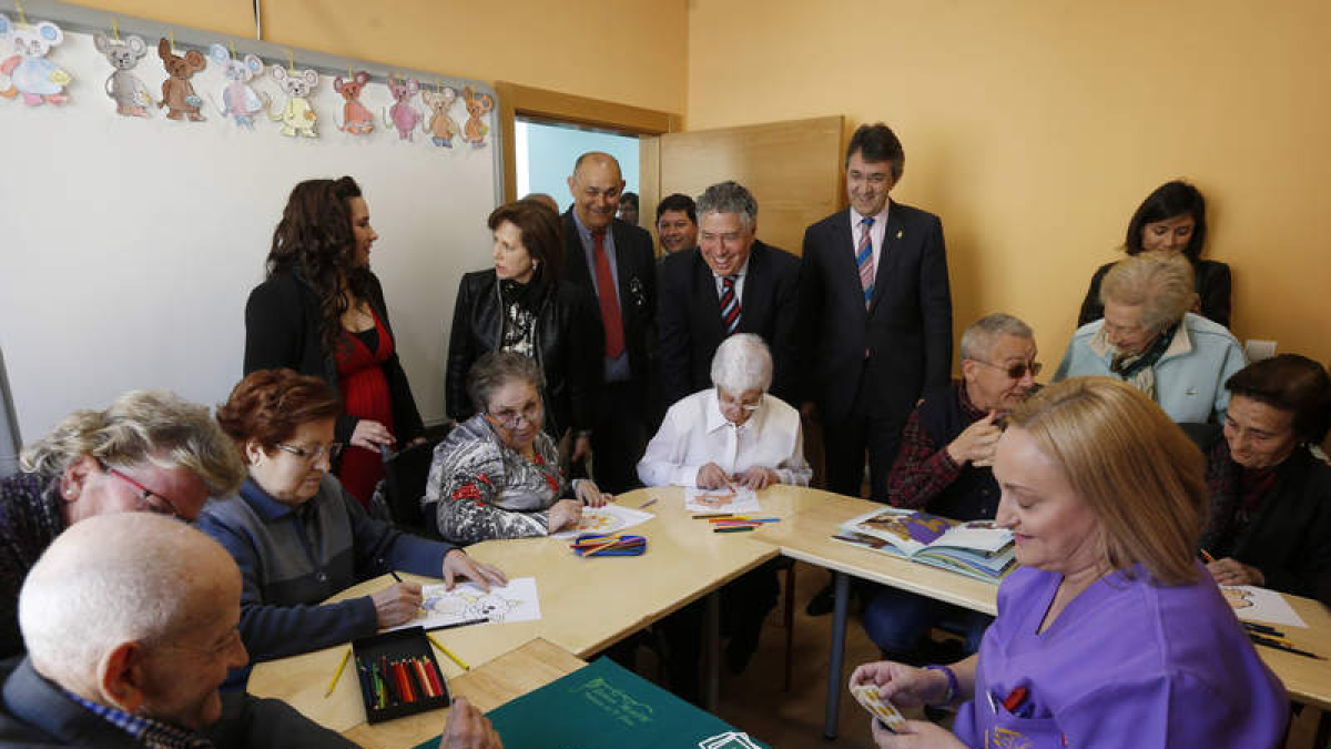 Al la izquierda, el secretario de Estado y el alcalde con los usuarios del aula de alzhéimer; a la derecha saludan a varias personas durante la inauguración. JESÚS F. SALVADORES