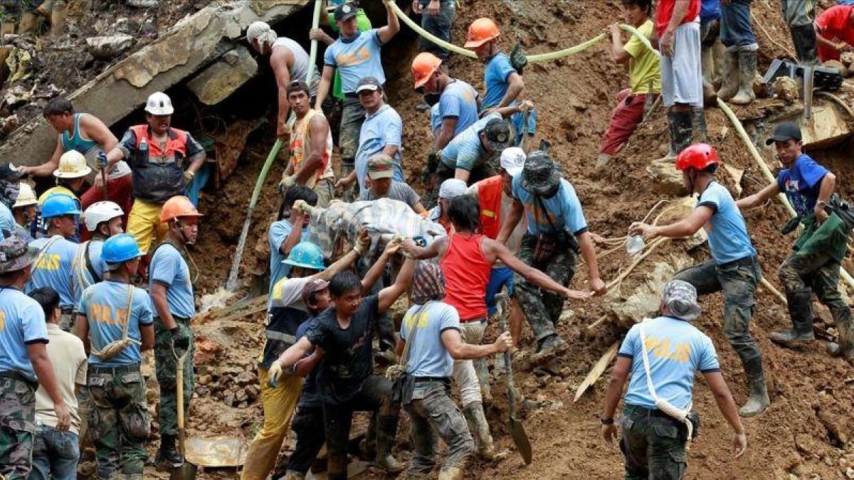 Equipos de socorristas sacan de la mina el cadáver de uno de los mineros víctimas del tifón Mangkhut.