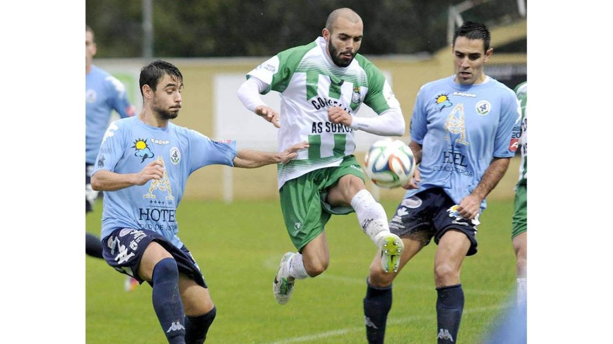 Taranilla, a la izquierda, disputa un balón con un jugador del equipo gallego bajo la atenta mirada de Porfirio