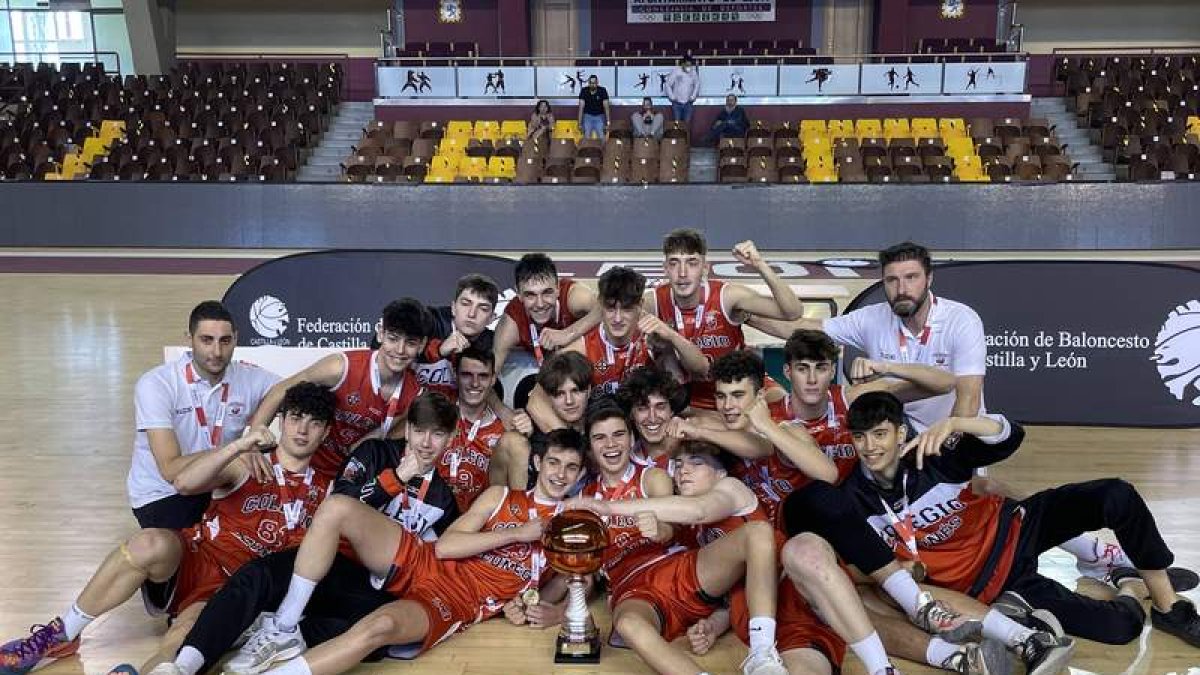 Los integrantes del Colegio Leonés posan con el trofeo de campeones al término de la final a cuarto. DL