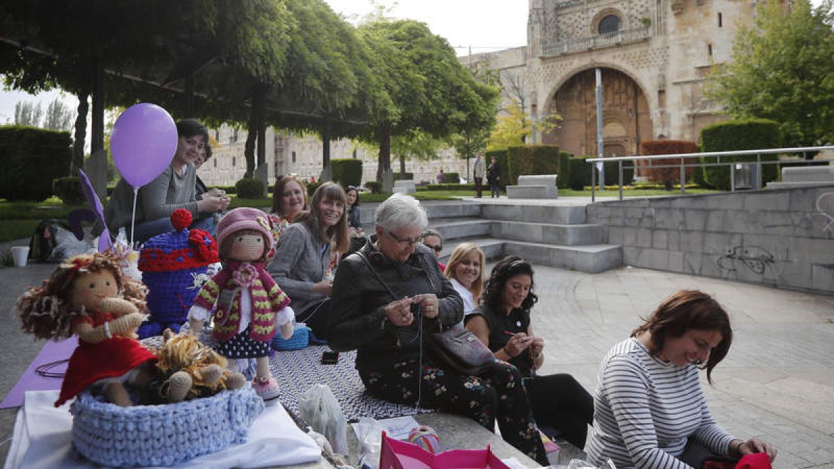 Un grupo de mujeres en el anfiteatro de la plaza de San Marcos teje para reivindicar esta actividad, ayer en León. JESÚS F. SALVADORES