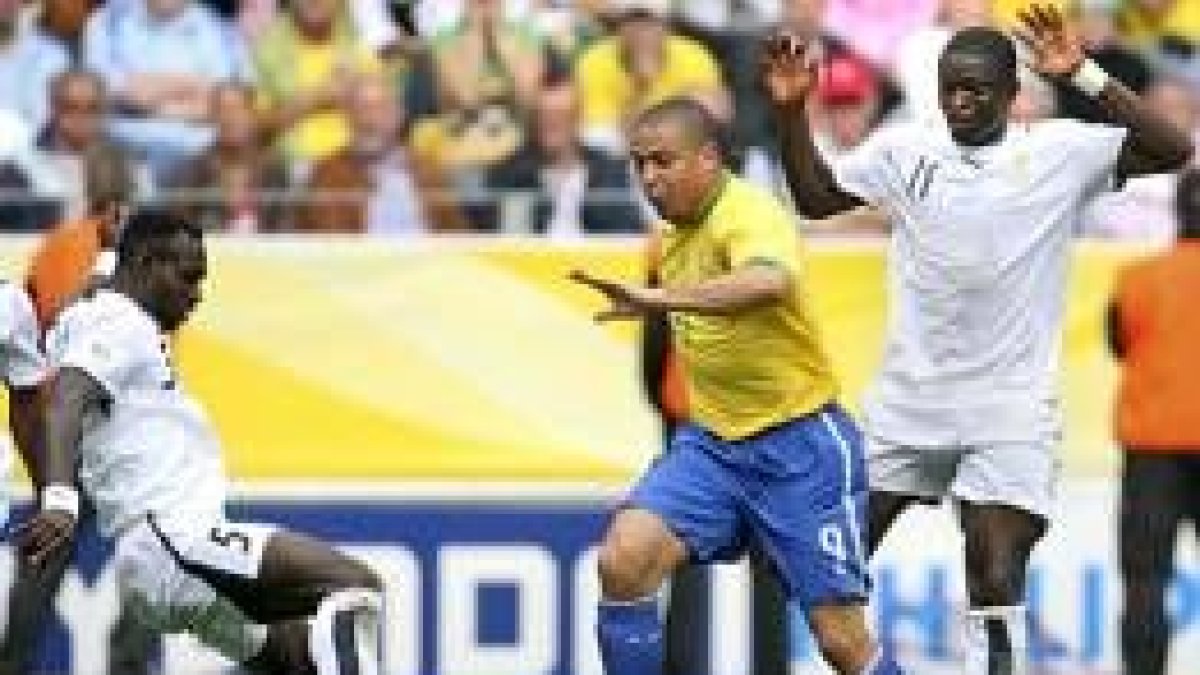 El brasileño Ronaldo lucha por el balón con los jugadores de Ghana Sulley Muntari y John Mensah