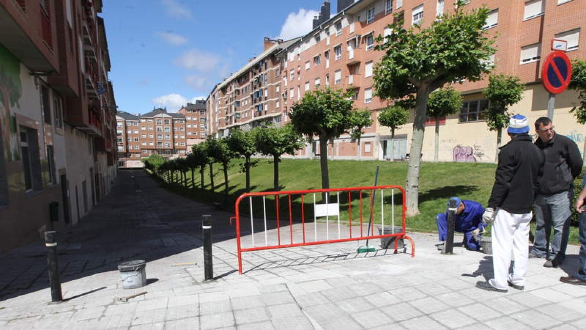 Operarios municipales, colocando ayer los bolardos en la calle Valle del Silencio.