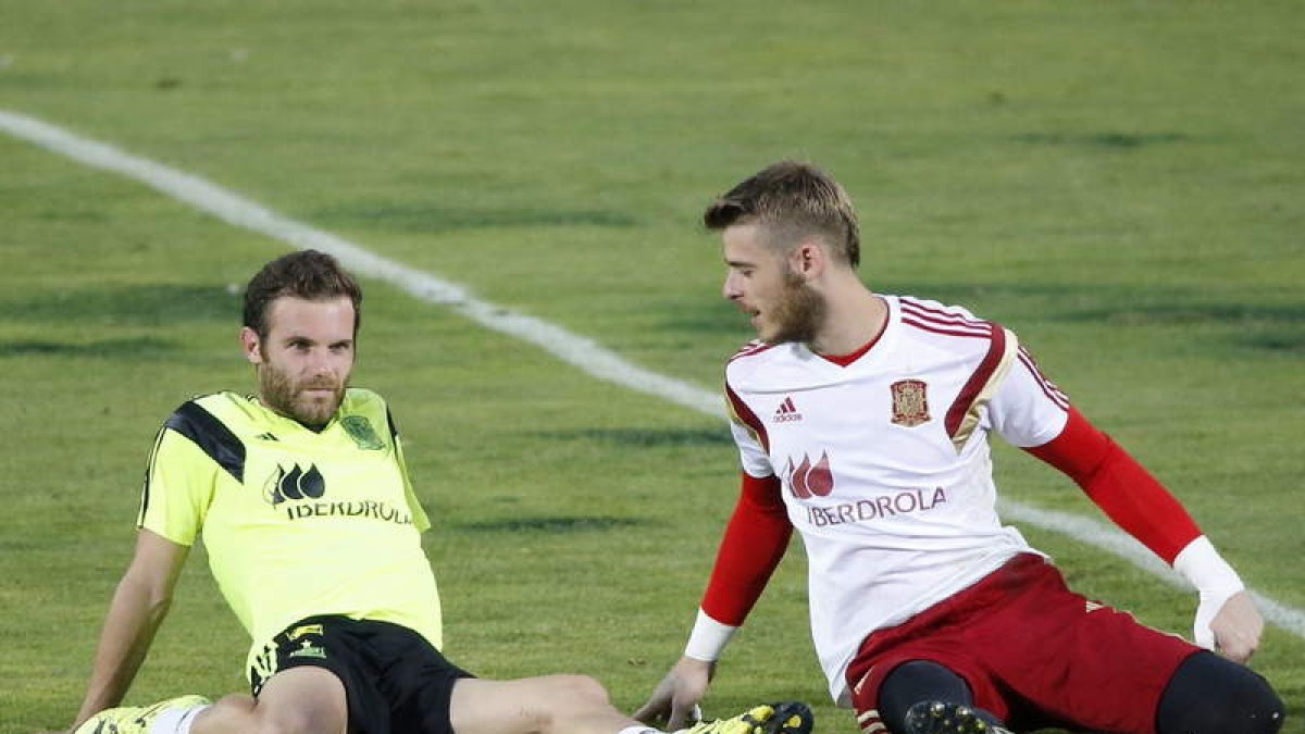 Juan Mata y David De Gea conversan durante el entrenamiento de ayer