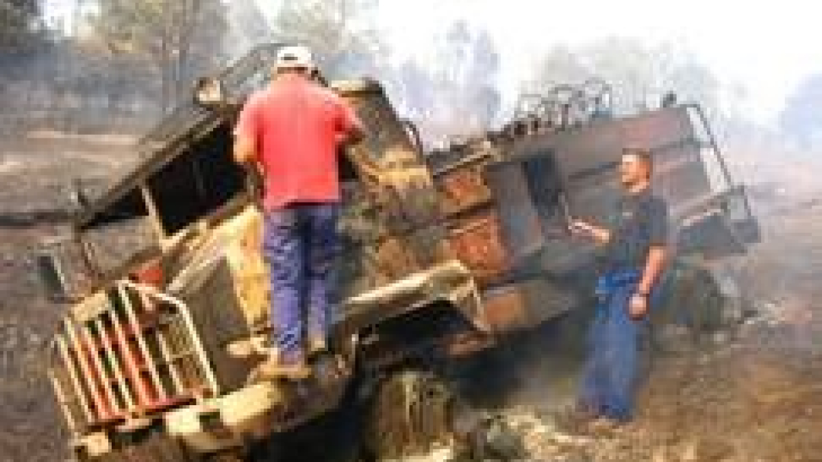 Dos operarios de la Mancomunidad de La Cepeda observan el estado en el que quedó el vehículo