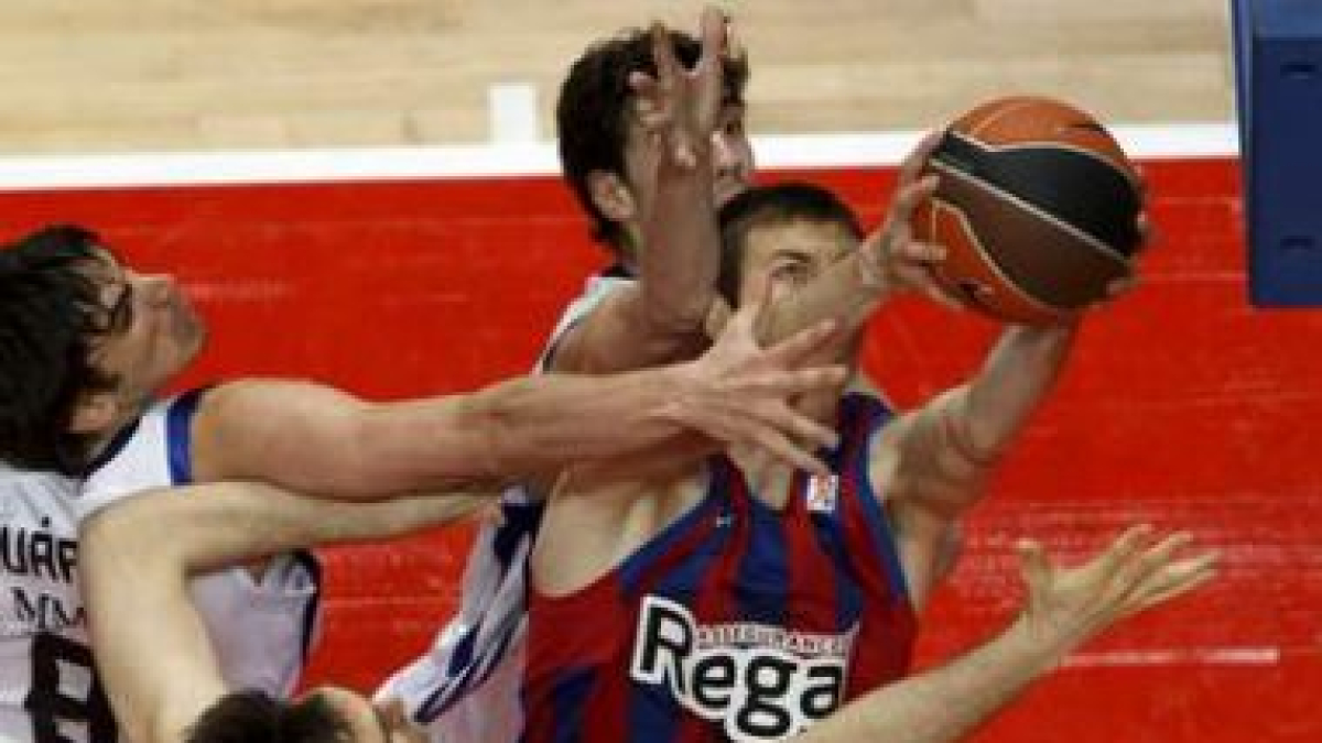 Fran Vázquez capura un rebote ofensivo ante la oposición de Sergio Llull y Carlos Suárez.