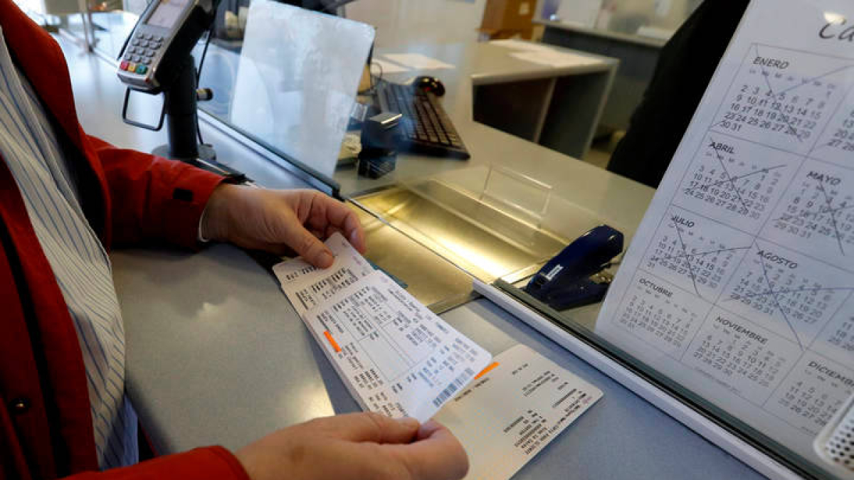 Una persona recoge unos billetes de tren. MARCIANO PÉREZ