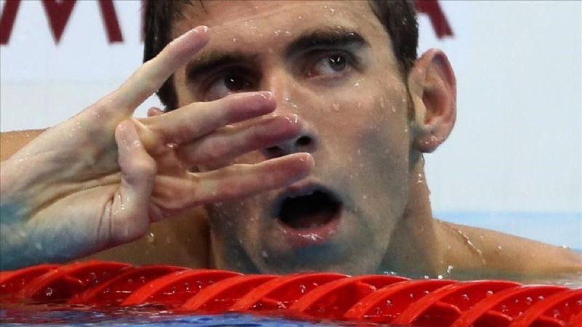 Phelps alza cuatro dedos en la llegada de los 200 estilos para reflejar los cuatro títulos consecutivos en esta prueba desde Atenas