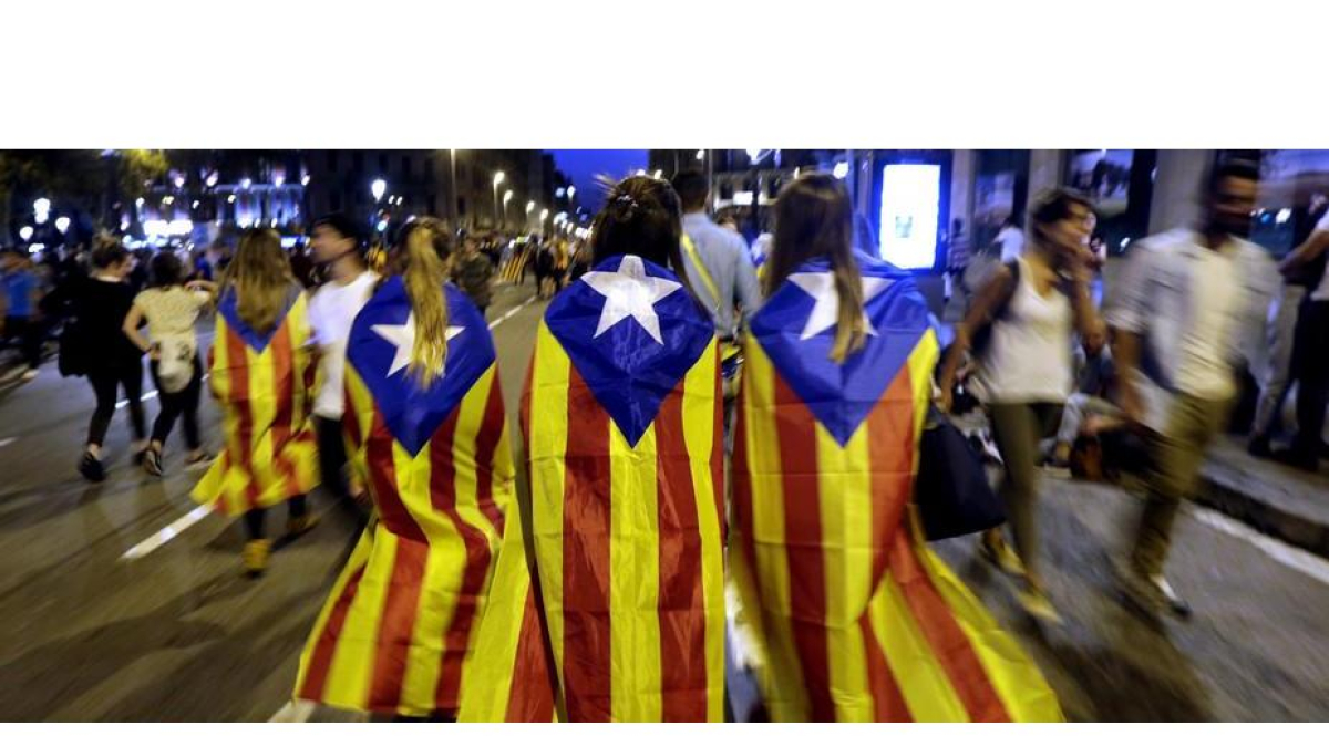 Varias jóvenes con banderas esteladas caminan por plaza de Catalunya tras la manifestación llevada a cabo en la plaza de la Universidad de Barcelona, en protesta por las cargas policiales del 1-O.