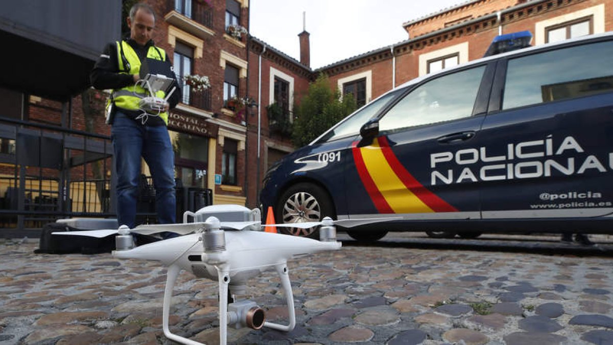 Los policías nacionales acompañan, ayer, al operador de drones para comprobar que todo está en regla. RAMIRO