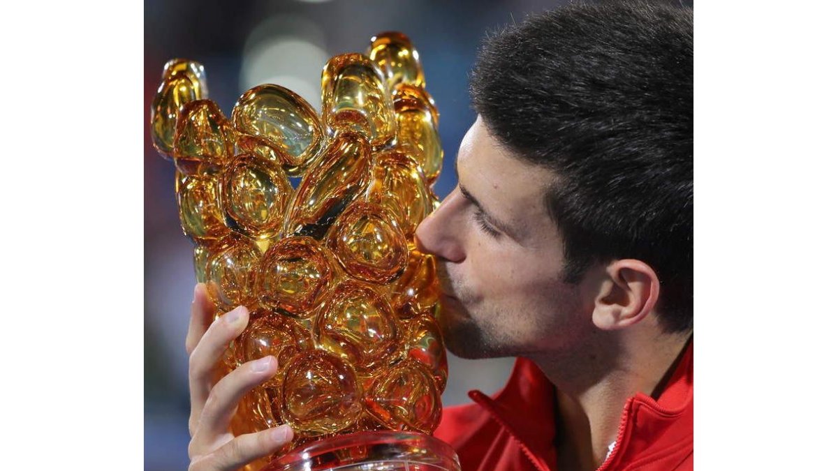 El tenista serbio besa el trofeo de ganador en Abu Dabi tras derrotar a Ferrer en la final.