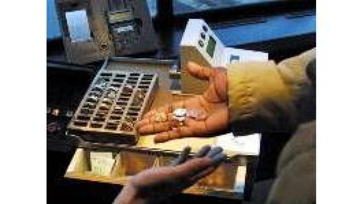 Un hombre paga con céntinos de euro su billete de autobús urbano