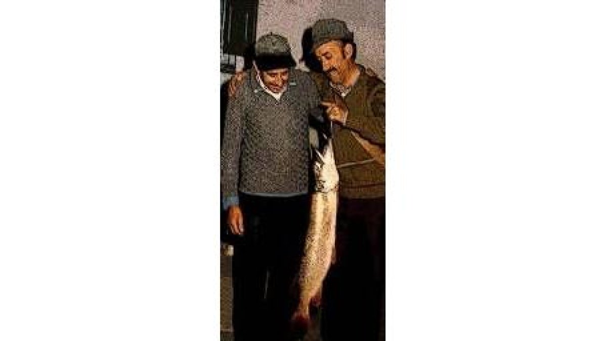 El Chepa presta atención a la conversación y al fenomenal  lucio que  pescó su amigo
