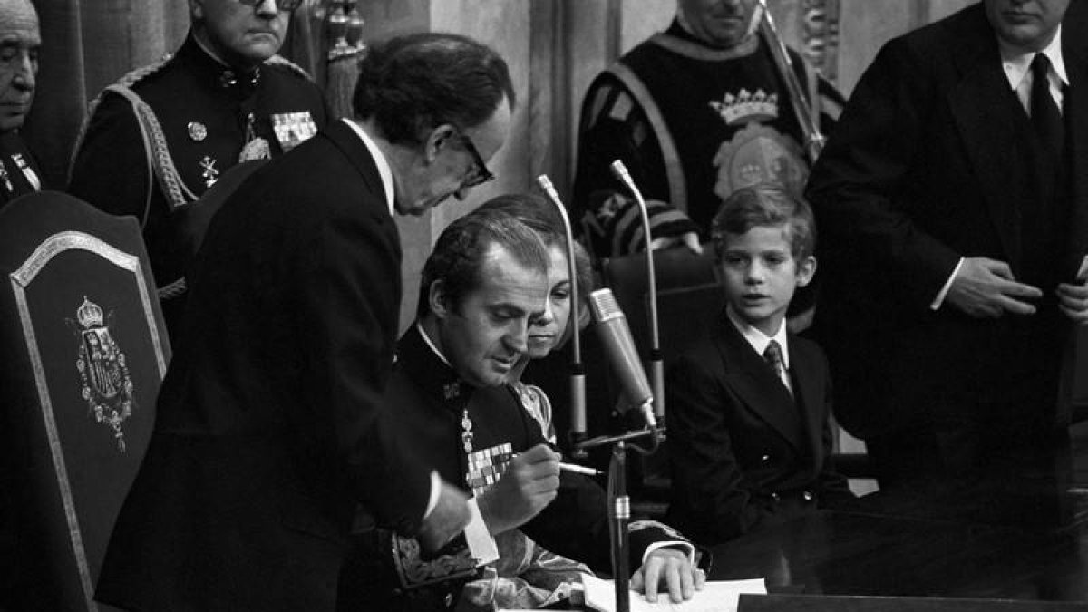 Don Juan Carlos sanciona la Constitución durante un acto celebrado en el Congreso de los Diputados, en presencia de doña Sofía, un jovencísimo príncipe Felipe y del presidente de las Cortes, Antonio Hernández Gil
