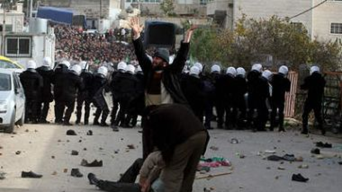 Un hombre pide ayuda mientras seguidores palestinos de Hamas lanzan piedras a la policía