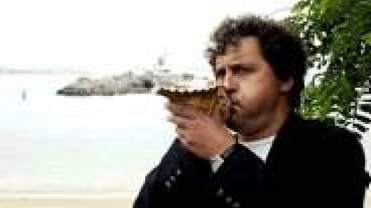 Manuel Rivas sopla una caracola frente a la bahía de Santander