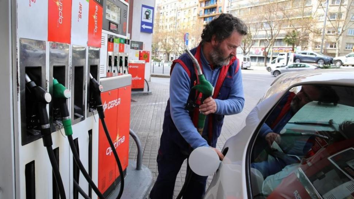Un conductor repostan en la gasolinera de Barcelona.