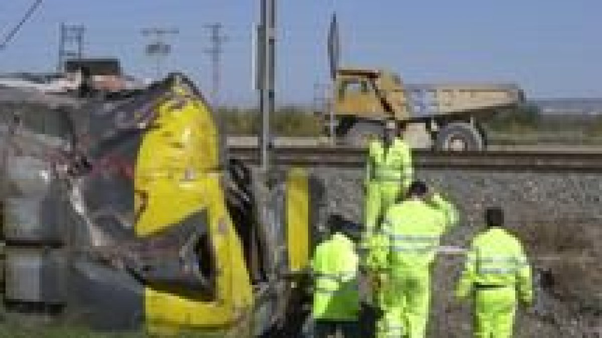 Unos operarios retirar los restos del camión que chocó contra el tren de Zaragoza