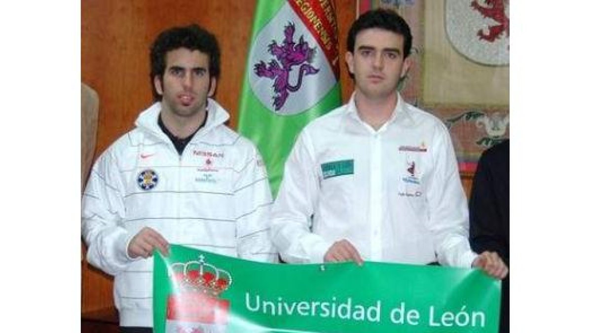 Javier Alonso y Jorge García con el emblema de la Universidad