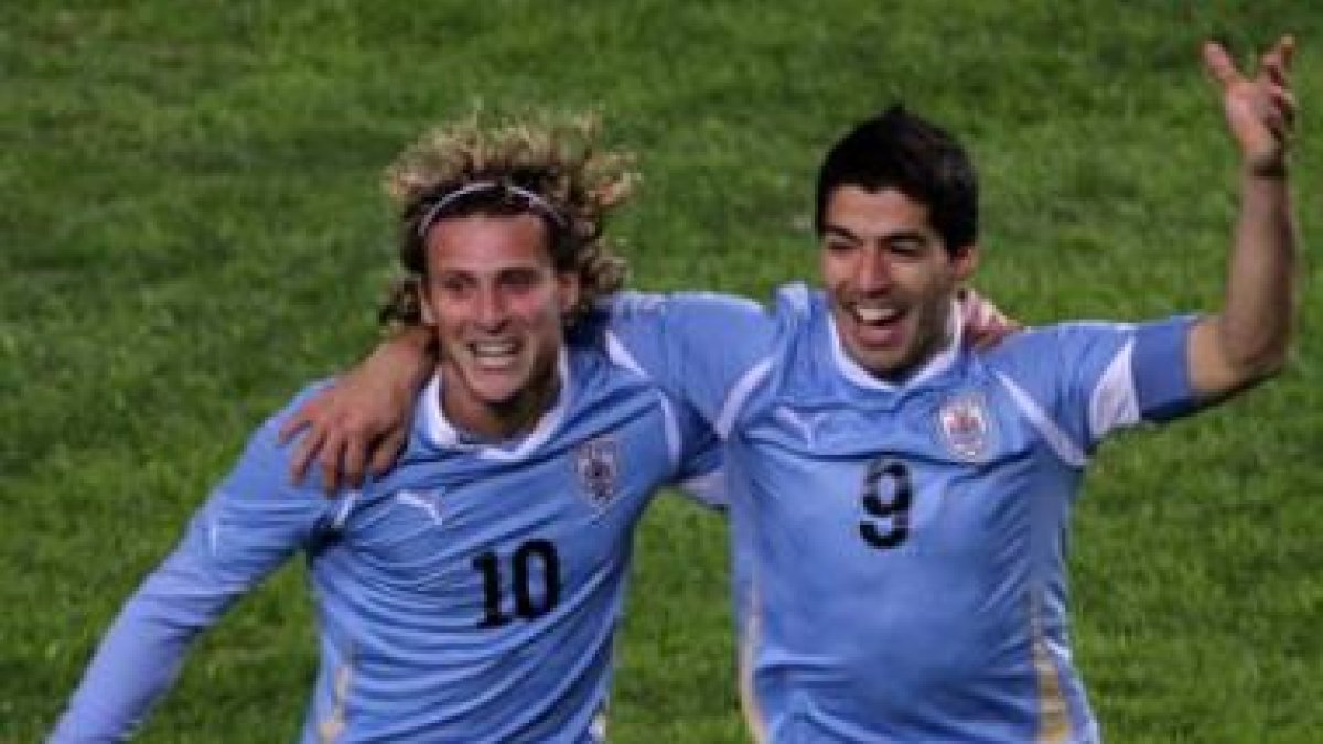 Luis Suárez celebra con Forlán uno de los goles.