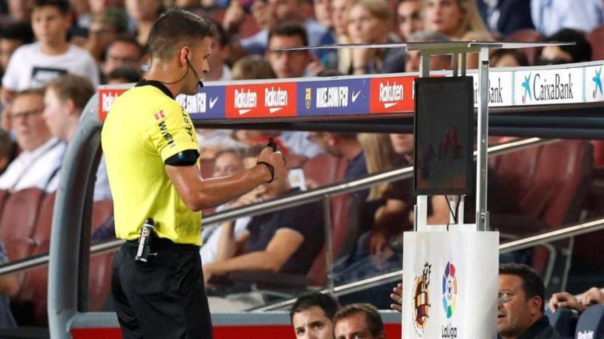 Gil Manzano chequea la jugada que condujo a la expulsión de Lenglet, en el Barça-Girona de Liga.