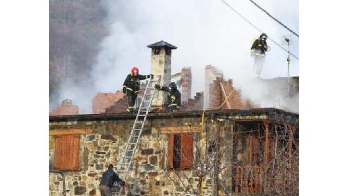 Los bomberos en plena extinción, auxiliados por los vecinos de Pereda de Ancares.