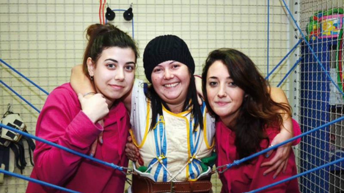 Los fisioterapeutas Clara Moros y Raquel Pérez trabajan con una de las pacientes.