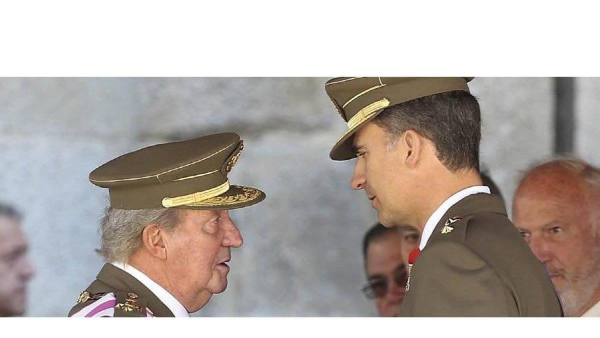 El rey y el príncipe conversan durante el acto castrense celebrado ayer en El Escorial.