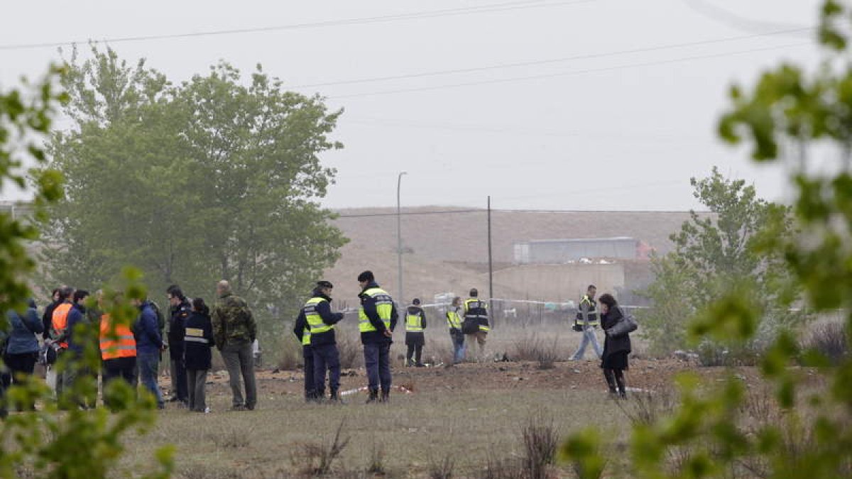 Bomberos y policías recorren el descampado donde se estrelló el avión.